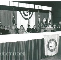 Speech makers at podium at Baltimore homecoming.