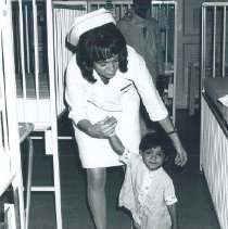 Mary Carol Clark with child who learned to walk on the SS HOPE in Ceylon.