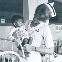 Doris Beister holding a Pediatric patient on the SS HOPE in Ceylon.