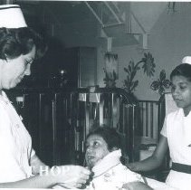 Darlene Padgett and counterpart with patient on the SS HOPE in Ceylon.