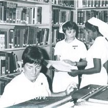 Harriet Weller and Joelyn Bymoen with library counterpart on SS HOPE Ceylon
