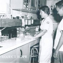 Lois Boyce with counterpart in laboratory on the SS HOPE in Indonesia 1960.