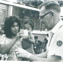 Unknown doctor with mother feeding child HOPE milk on the SS HOPE in Quayaq