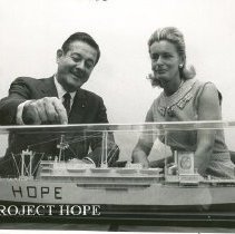 William B Walsh showing large replica of SS HOPE to Mrs Robert Sarnoff