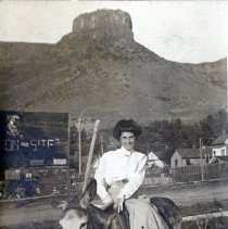 1910 picture postcard of a woman sitting sidesaddle on a mule, color correc