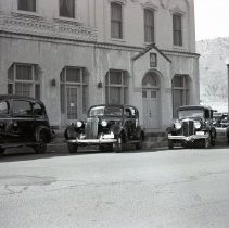 View of hearses in front of Woods Mortuary, Golden