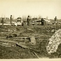 Men walking through tornado rubble 1899 Apr