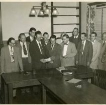 KCOS Faculty & administration looking at booklet ca. late 1940s
