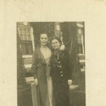 Women standing in dresses in front of brick building 1932-1942