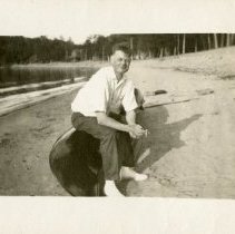 Man Sitting on Canoe at the Beach