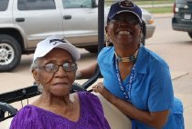Mamie Norville Seated With Unknown Woman Wearing Blue Baseball Hat