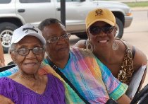Mamie Norville Seated With Two Women, One Without Baseball Hat