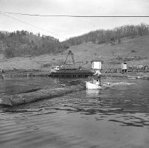 Moving logs on pond w/ boat