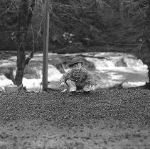 Small boy on bank of river