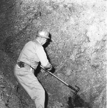 Mill worker clearing chips