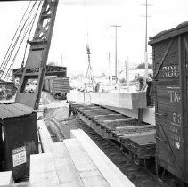 Loading lumber onto flatbed railroad car