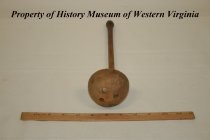 Wooden ladle with three holes in the bottom.