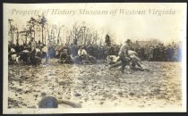 Young men wrestling in mud
