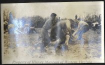 Young men wrestling in mud