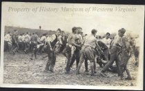 Young men wrestling in mud