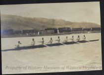 Crew rowing in front of train