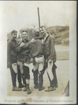 Four men in torn and muddy clothes