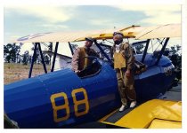 Maggie Gee and a man standing on a biplane
