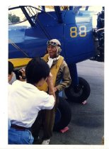 Maggie Gee being photographed next to a biplane