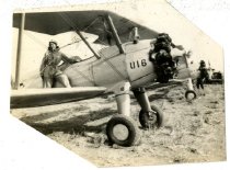 Maggie Gee standing on the wing of a biplane