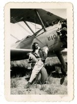 A woman sitting on the wheel of a biplane-Front