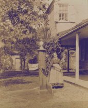 Woman at Pump Outside of Cedar Grove