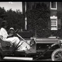Unidentified woman and boy in an automobile at Breakwater House