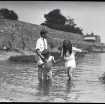 Children of the Iselin family in the Long Island Sound (Breakwater House and Breakwater Cottage visible in background)