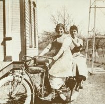 Two women on parked Indian motorcycle, n.d.