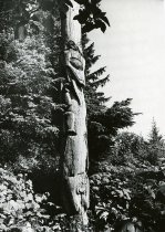 Bear biting tail of whale totem pole