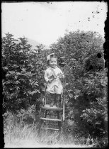 Girl standing on chair outside