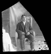 Young man seated in wicker chair