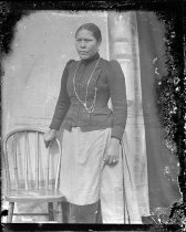 Woman standing by chair