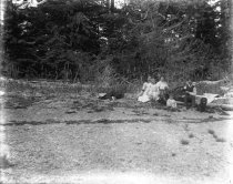 Women, man, and children on the shore of a beach