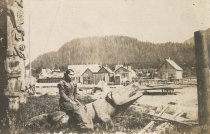 Native woman sitting on totem figure
