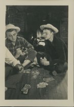 Photograph of Clark Jamison and Stuart Light playing cards while camping