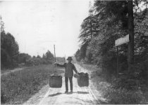 Suey Kee walking with produce on carrying pole, 1902