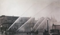 Firemen spraying fire hoses, early 1900s