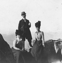 Three people opn the top of Mt. Tamalpais, date unknown