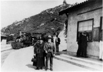 Couple standing at the train depot of the Tavern of Tamalpais, 1896-1920