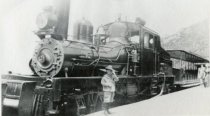 Child posing by the Mount Tamalpais Scenic Railway engine No. 8, 1900-1930