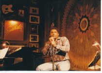 Aaron Neville sitting at mic