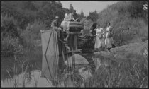 Sitting on an overturned vehicle in the creek, 1918