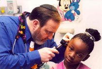 Israel Bochner examining patient's ear
