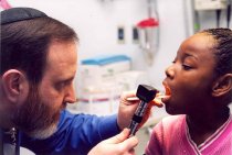 Israel Bochner examining patient's mouth